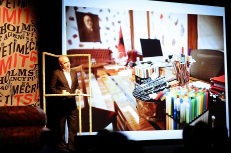 Edi Rama in a fluffy yellow frame, his desk on the background.